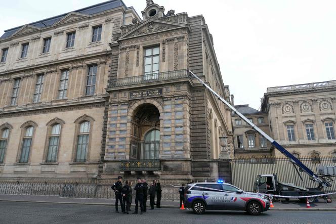 Des policiers se tiennent à côté d’un monte-meubles utilisé par des cambrioleurs pour pénétrer dans le Musée du Louvre, sur le quai François-Mitterrand, à Paris, le 19 octobre 2025. DIMITAR DILKOFF/AFP
