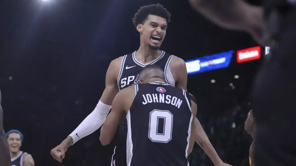 Victor Wembanyama (haut) des San Antonio Spurs avec Keldon Johnson (bas) lors d'un match de NBA contre les Indiana Pacers à Paris, jeudi 23 janvier 2025.